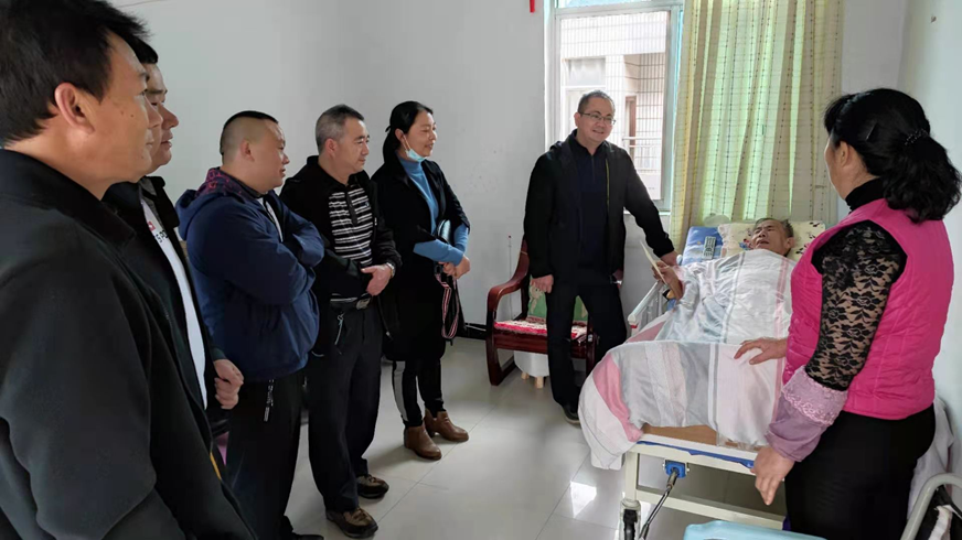 图为慰问小组看望生病退休的老职工
